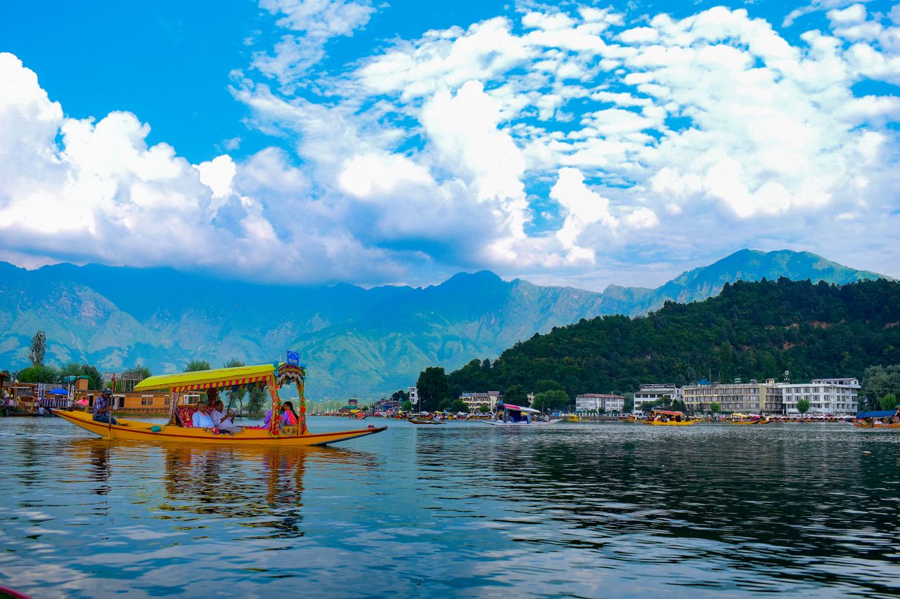 gallery-4 Colorful shikara boat on Dal Lake with stunning Himalayan backdrop in Kashmir, India.