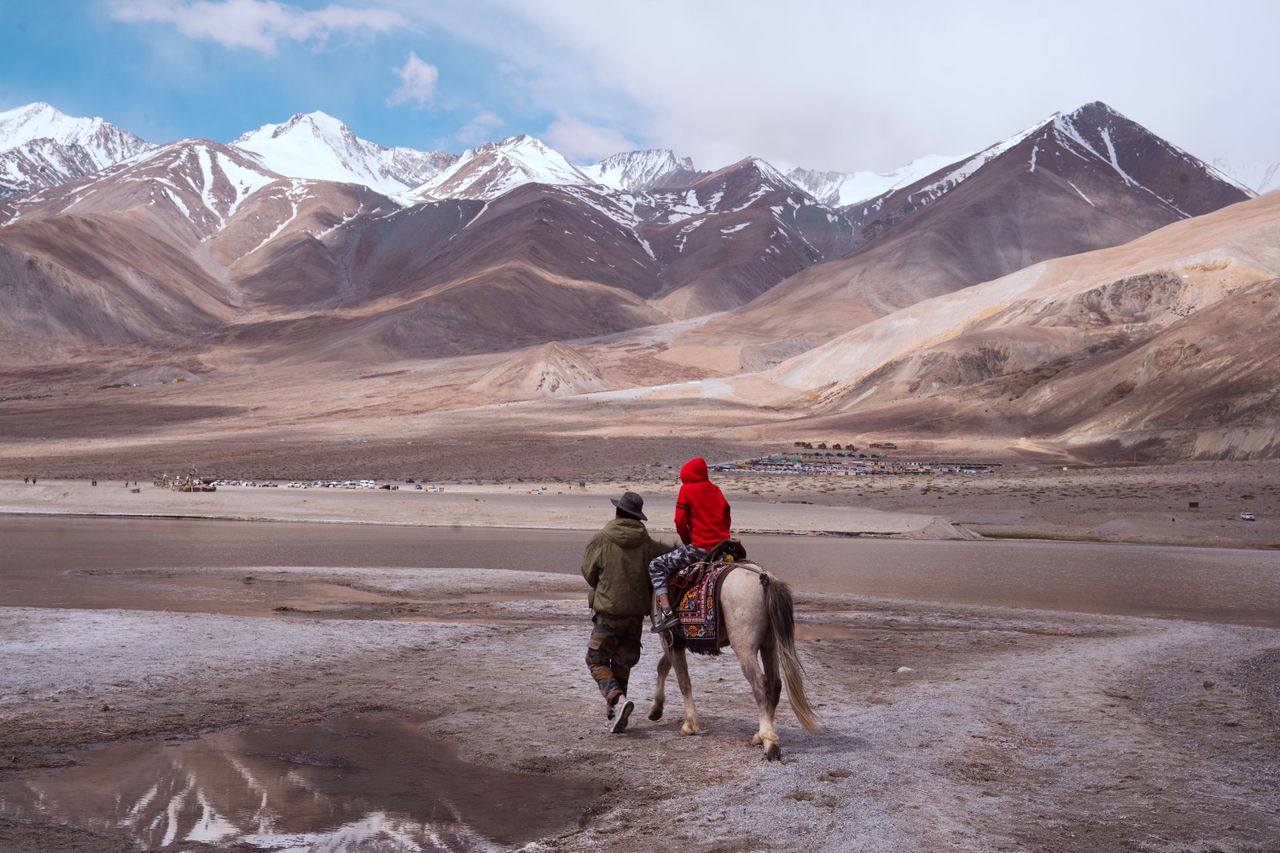 gallery-6 A person and child riding a horse in the breathtaking mountains of Ladakh, India.