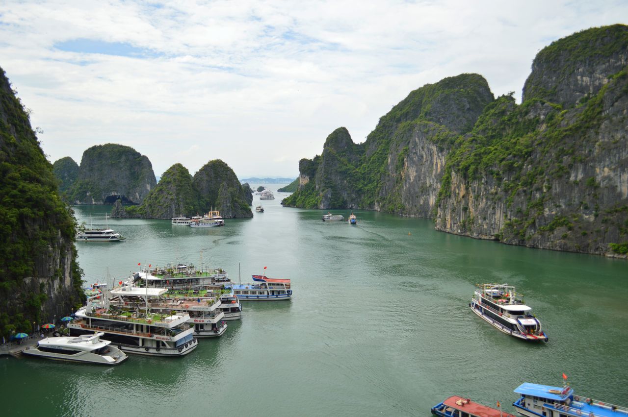 gallery-3 Explore Halong Bay's stunning limestone karsts and bustling cruise boats on a vibrant day.
